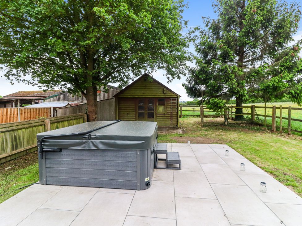 A garden with a hot tub and a shed at Tuffs Farm Cottage 2 in Kings Langley