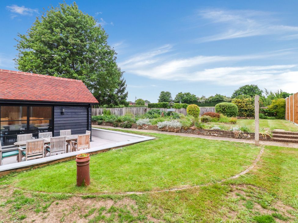 A garden area with a patio table and chairs at Tuffs Farm Cottage 2 Kings Langley