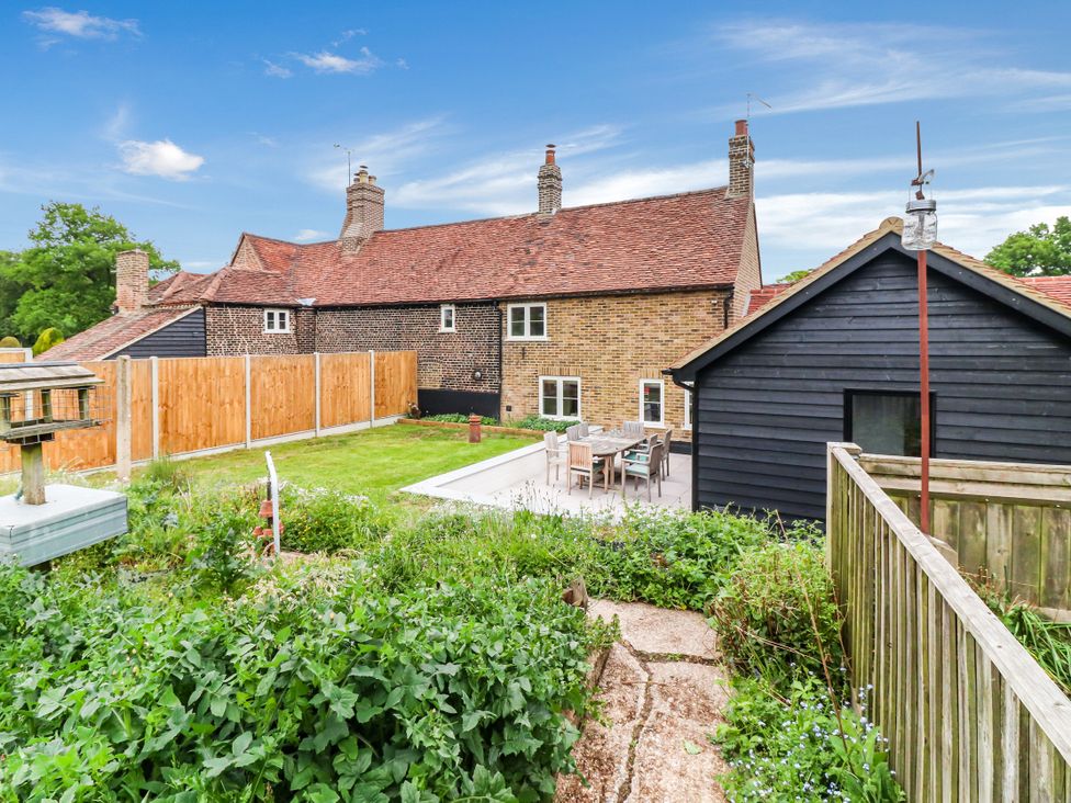 An outdoor area with a garden and seating at Tuffs Farm Cottage 2 in Kings Langley