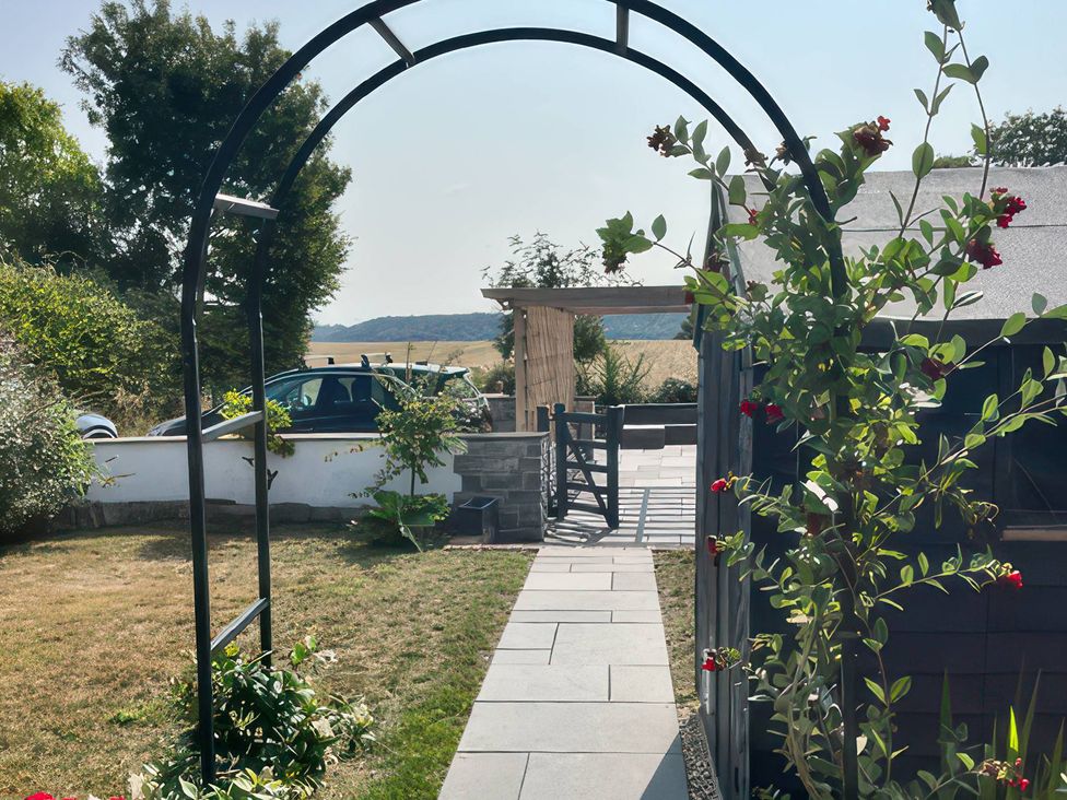 A garden with an arch entrance and pathway at Curlew Cottage North Curry near Taunton