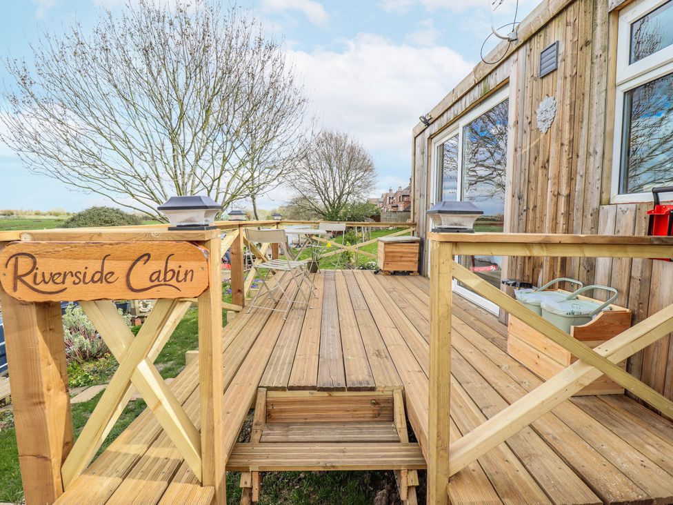 An outdoor deck with a sign at Riverside Cabin in Peterborough