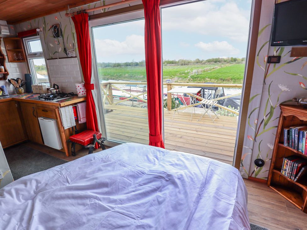 A bedroom with a kitchen and window at Riverside Cabin in Peterborough