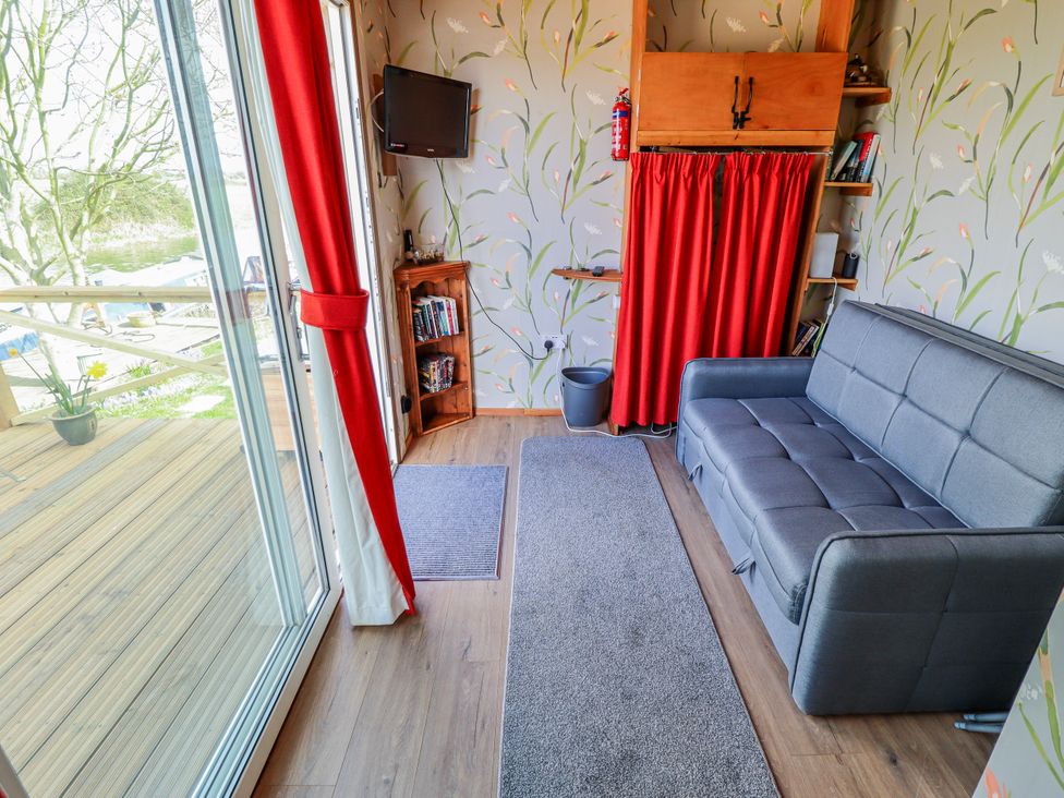 A living room with a sofa and television at Riverside Cabin in Peterborough