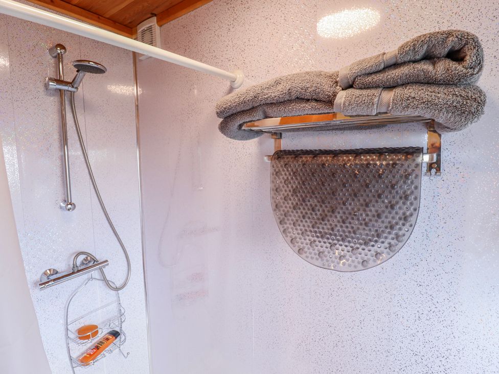 A shower with towel and towel rack at Riverside Cabin in Peterborough