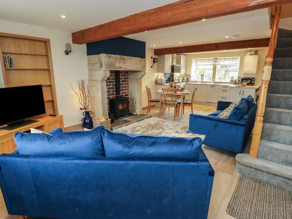 A living room with a sofa and television at Moss Cottage in Cragg Vale