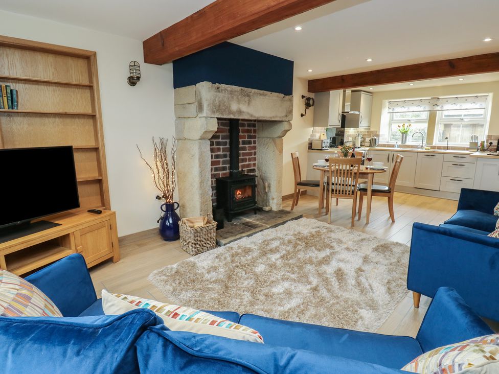 A living room with a fireplace and sofa at Moss Cottage in Cragg Vale