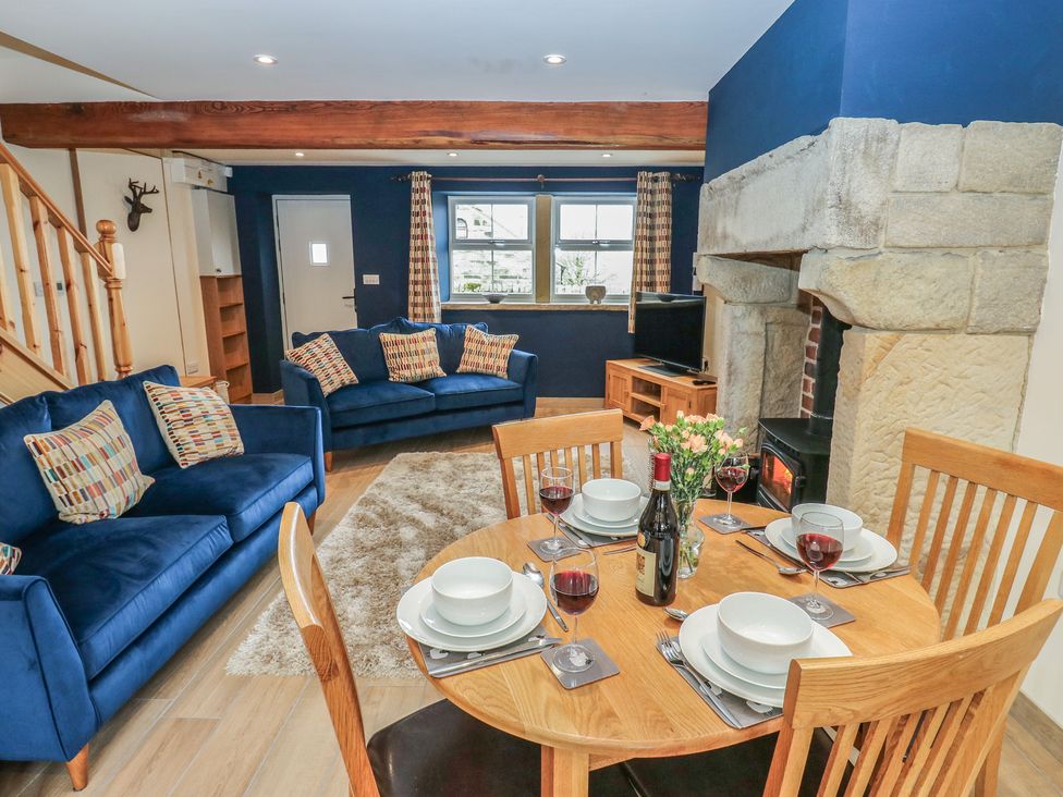 A living room with a table and chairs at Moss Cottage in Cragg Vale
