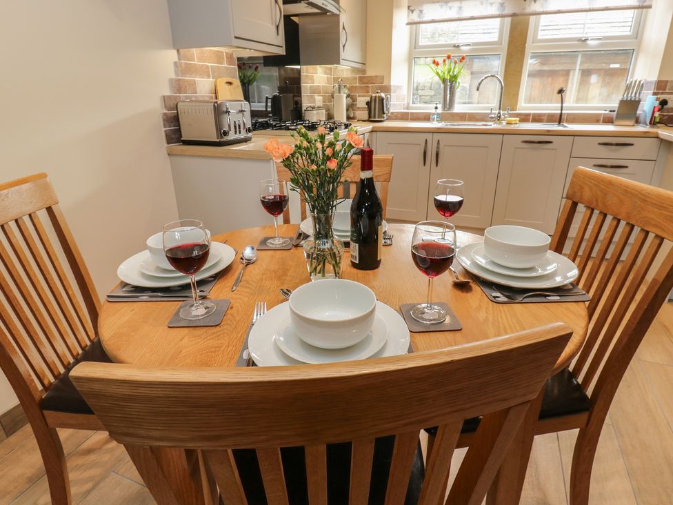 A dining room with a table set for four at Moss Cottage in Cragg Vale