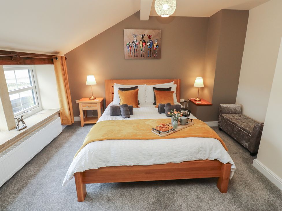 A bedroom with a bed and side tables at Moss Cottage in Cragg Vale