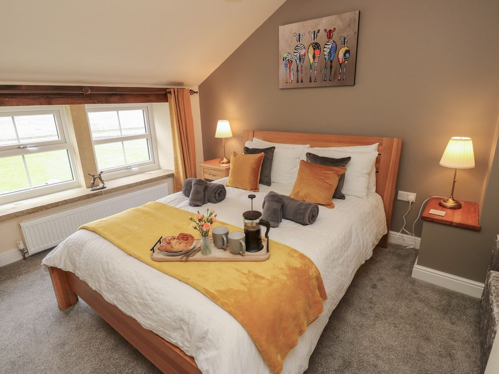 A bedroom with a bed and breakfast tray at Moss Cottage in Cragg Vale