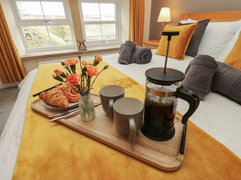 A bedroom with a tray of coffee and pastries at Moss Cottage in Cragg Vale