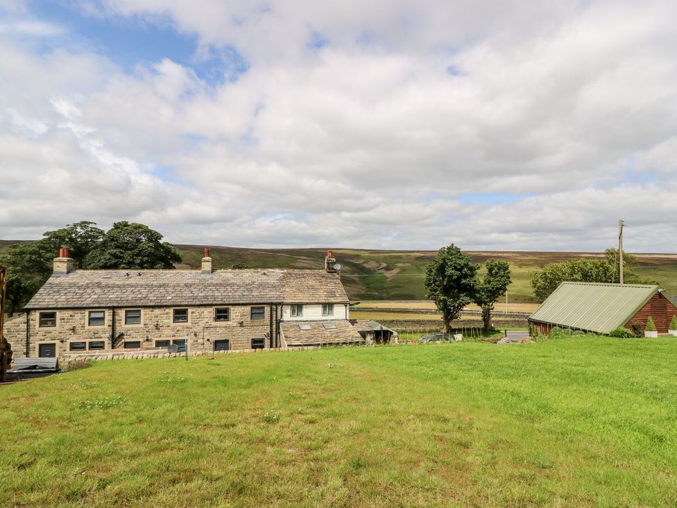 A house with trees and a shed in the field at Moss Cottage in Cragg Vale