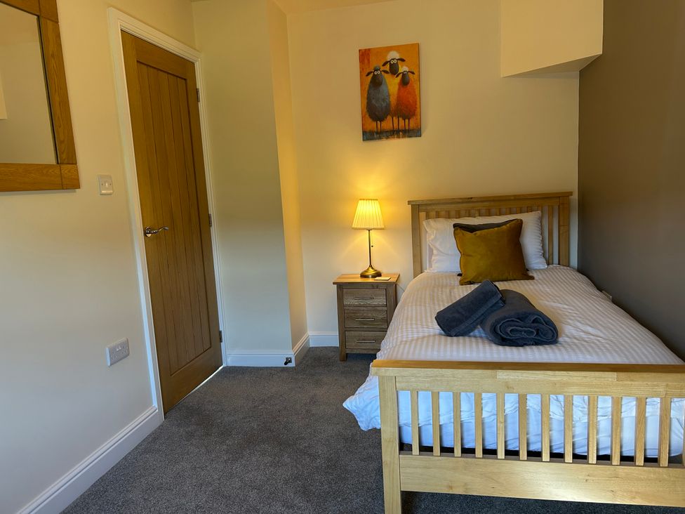 A bedroom with a bed and bedside table at Moss Cottage in Cragg Vale
