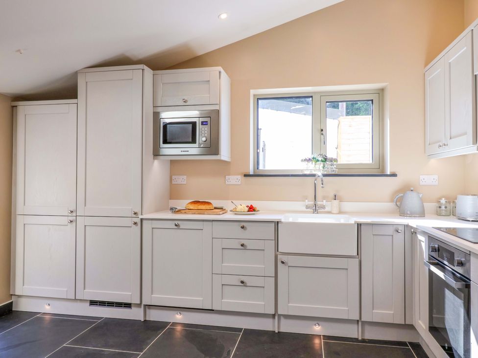 A kitchen with cabinets, countertop, sink and microwave at Heathmoor in Horrabridge