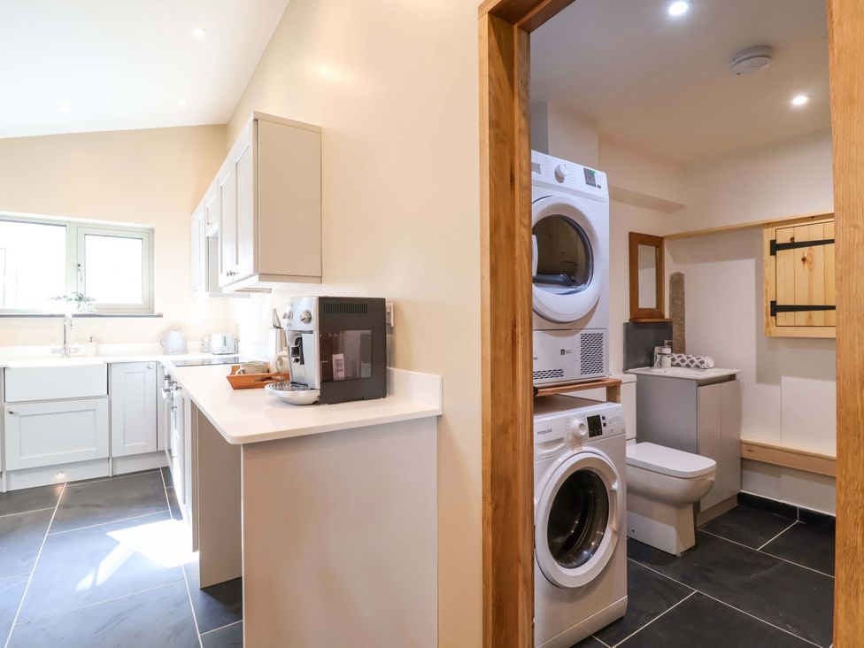 A kitchen with washing machine and dryer at Heathmoor in Horrabridge