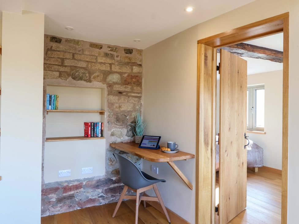 A study area with a desk and bookshelf at Heathmoor in Horrabridge