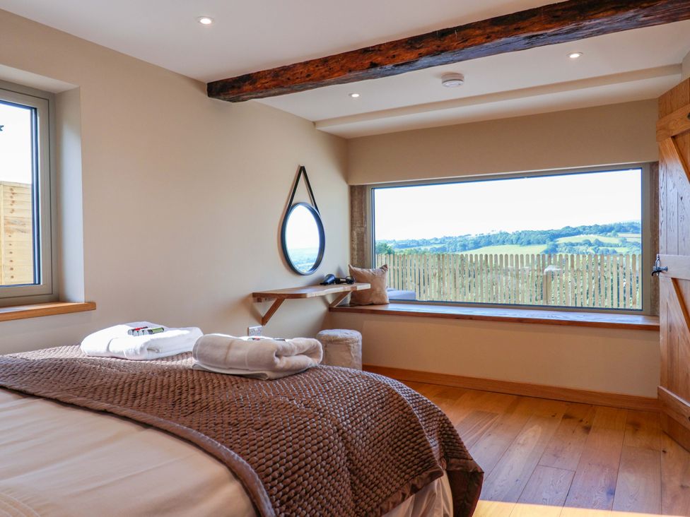 A bedroom with a bed and window at Heathmoor in Horrabridge
