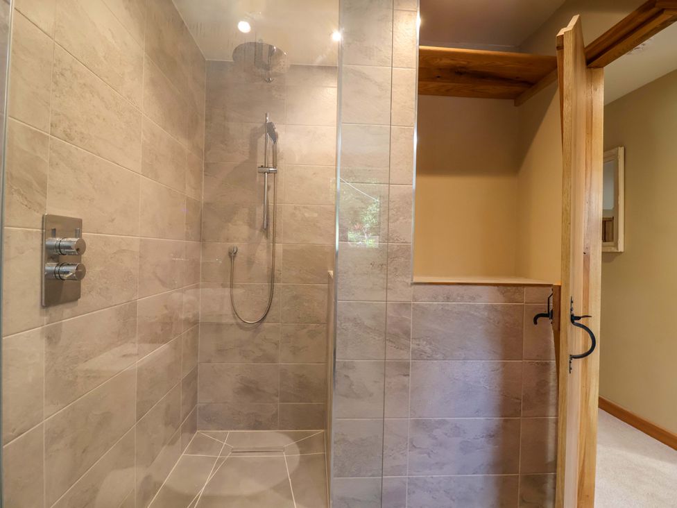 A shower area with tiles and wooden door at Heathmoor in Horrabridge