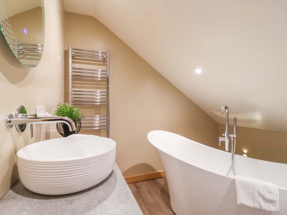 A bathroom with a bathtub and washbasin at Heathmoor in Horrabridge