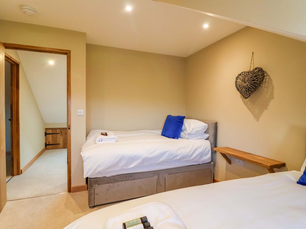 A bedroom with two beds and a door at Heathmoor in Horrabridge
