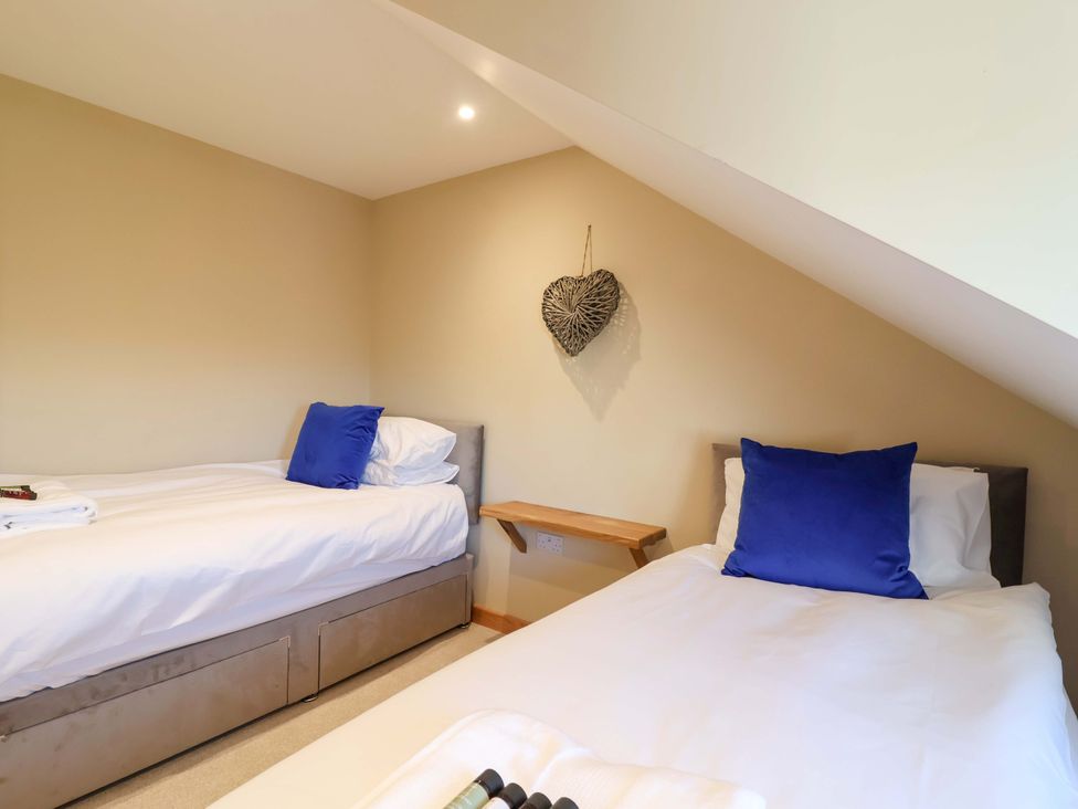 A bedroom with two single beds and a wooden table at Heathmoor in Horrabridge