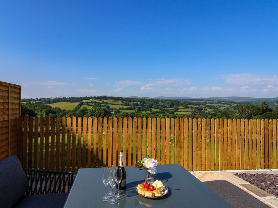 An outdoor dining area with a table and views at Heathmoor in Horrabridge