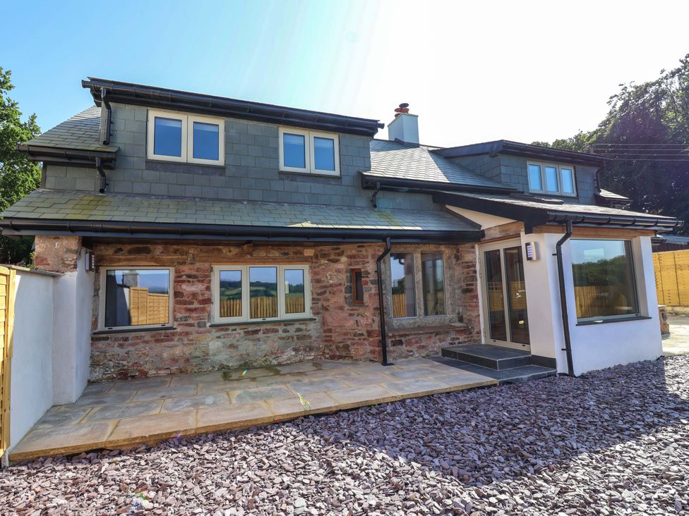 An exterior view of a house with a patio and stone walls at Heathmoor in Horrabridge