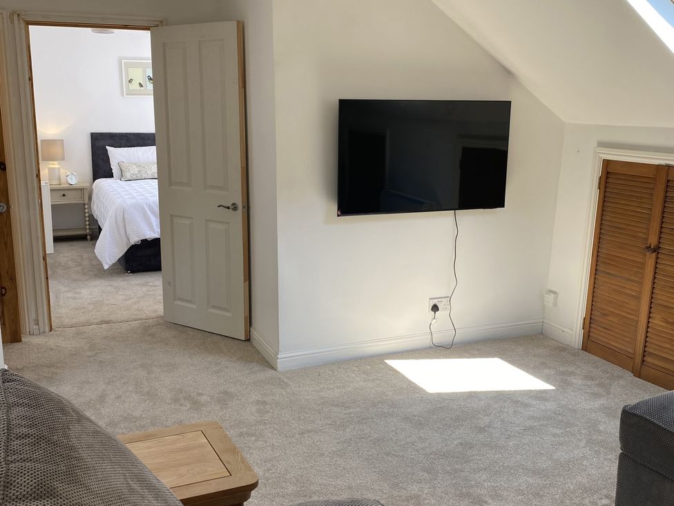 A bedroom with a television and door leading to another room at Old Forge Apartment Wolverly