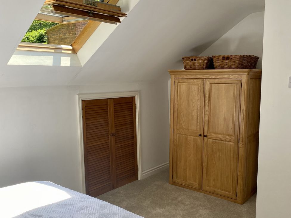 A bedroom with a wardrobe and baskets at Old Forge Apartment Wolverly