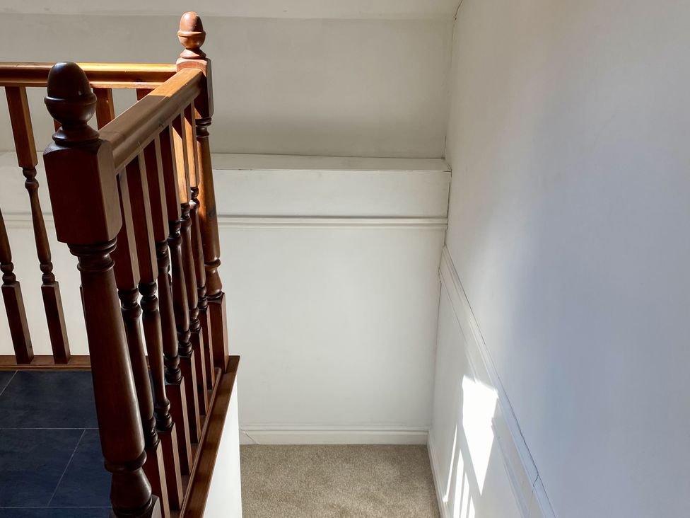 A staircase with wooden railing at Old Forge Apartment Wolverly