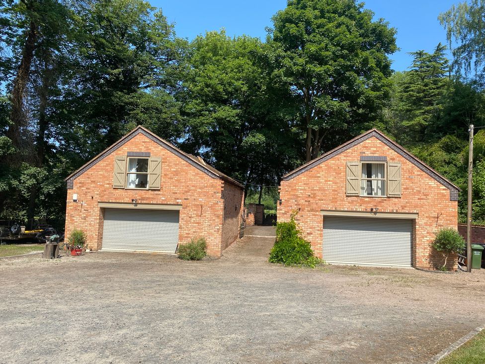 A two-garage building with a gravel driveway at Old Forge Apartment in Cookley