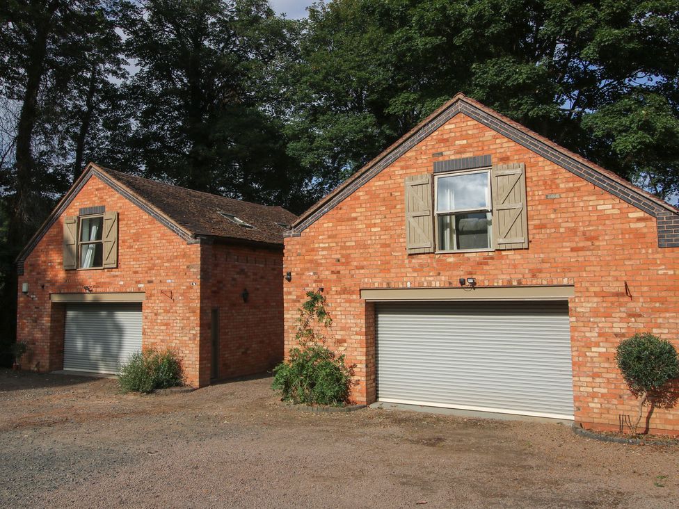 Two brick houses with garages and windows at Old Forge Apartment in Cookley