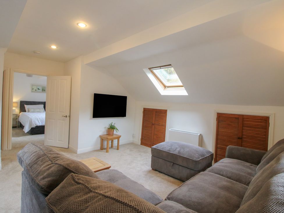 A living room with a sofa and television at Old Forge Apartment Cookley