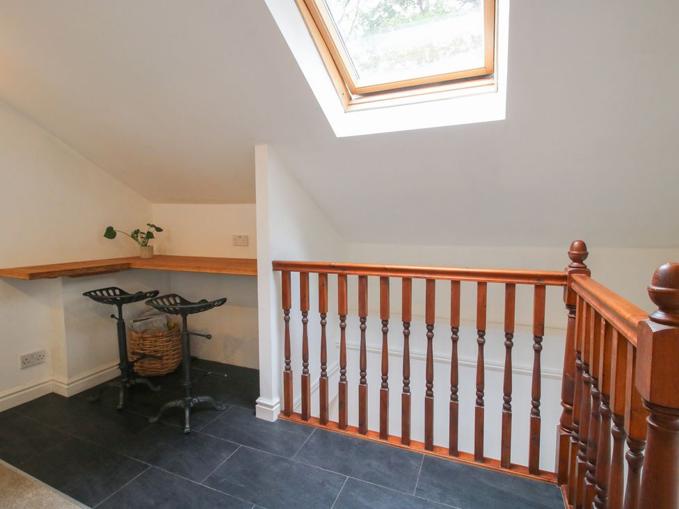 A landing area with a wooden railing and table at Old Forge Apartment in Cookley