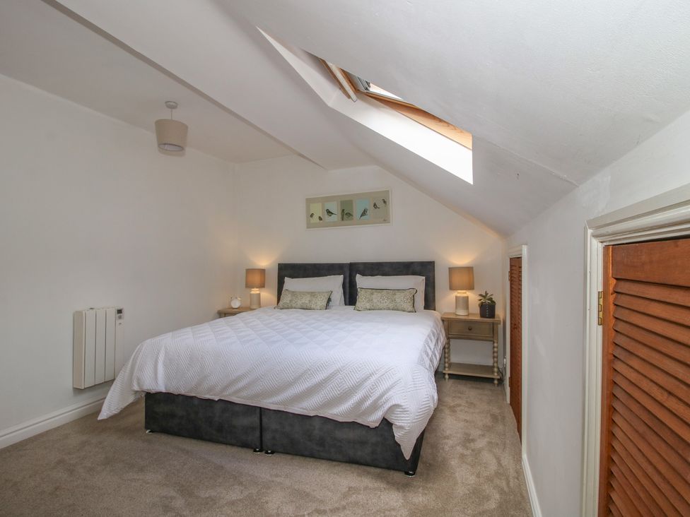 A bedroom with a bed and nightstands at Old Forge Apartment in Cookley