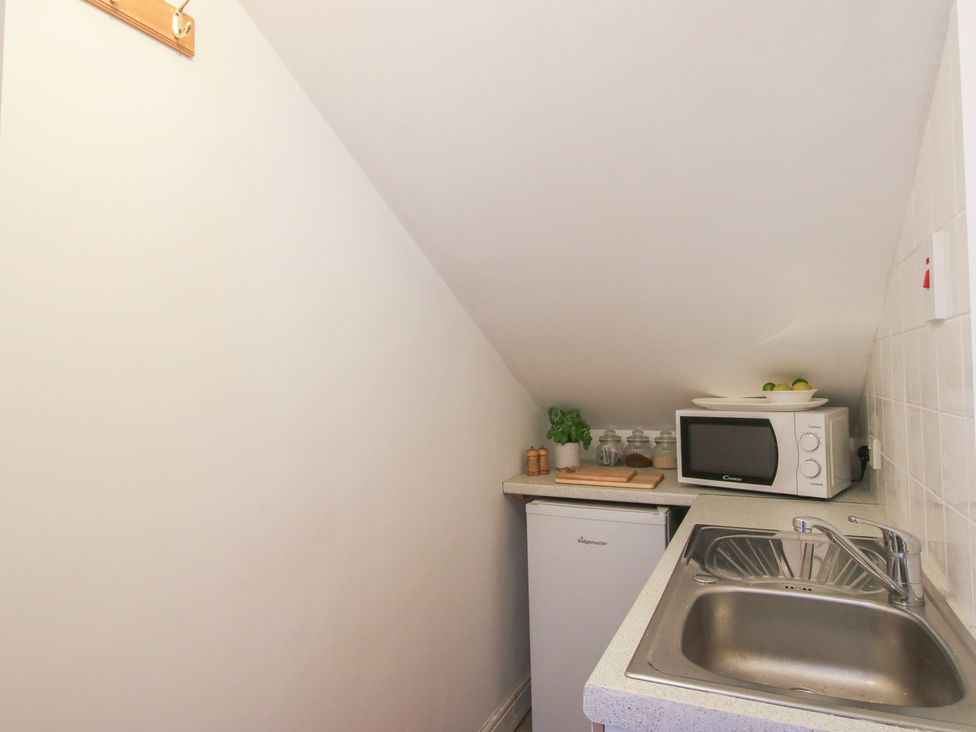 A kitchen area with a sink and microwave at Old Forge Apartment Cookley
