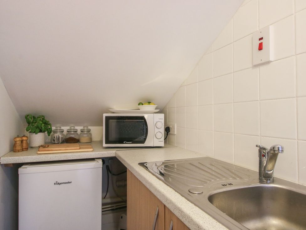 A kitchen with a sink, microwave, and fridge at Old Forge Apartment in Cookley