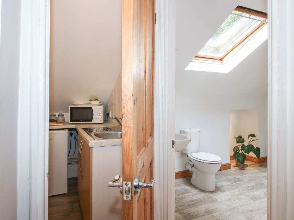 A bathroom with a toilet and a skylight at Old Forge Apartment in Cookley