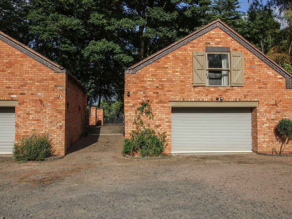 A view of garages with shutter doors at Old Forge Apartment in Cookley