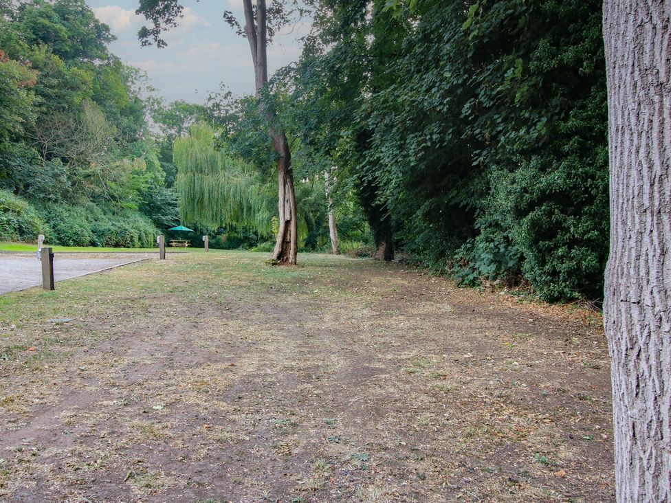 A path with trees and a bench at Old Forge Apartment in Cookley