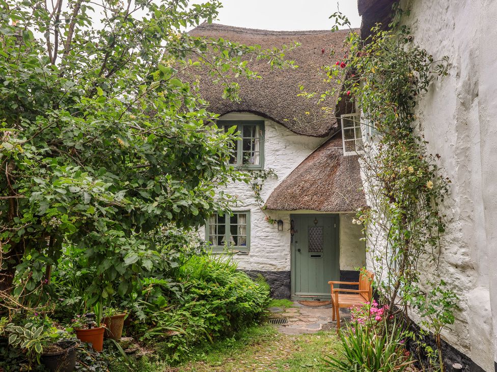 A garden with a thatched roof cottage at 3 Cumberland Cottages Ringmore
