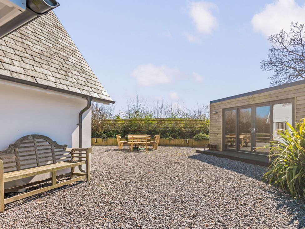 A garden with a wooden bench and seating area at Capton Snug Capton near Dartmouth