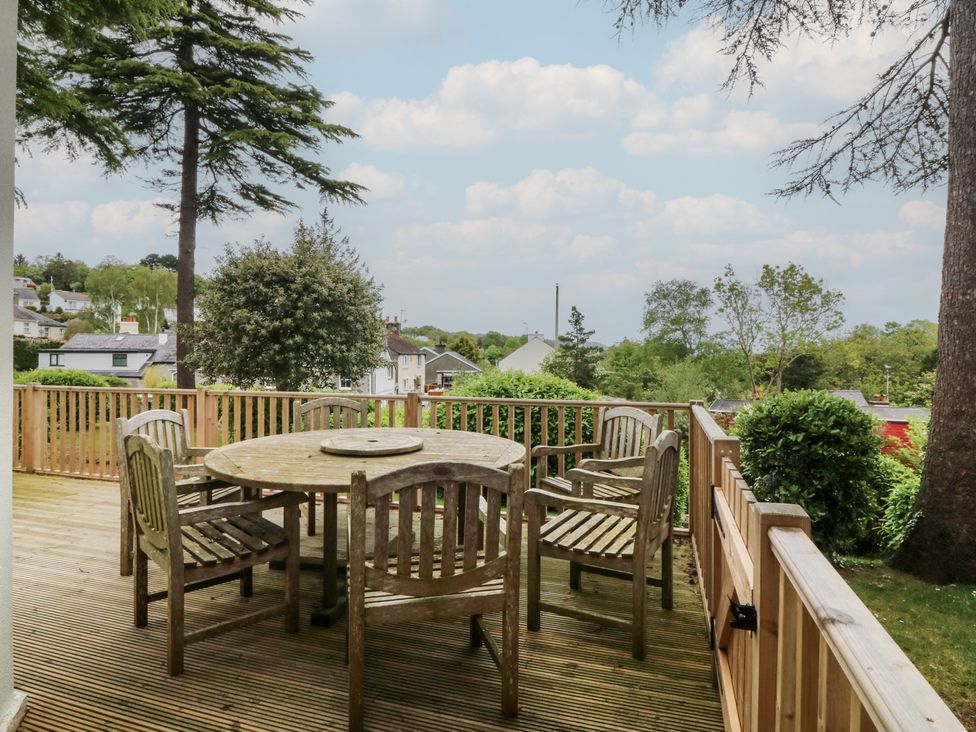 An outdoor space with a wooden table and chairs at Fir Grove Menai Bridge