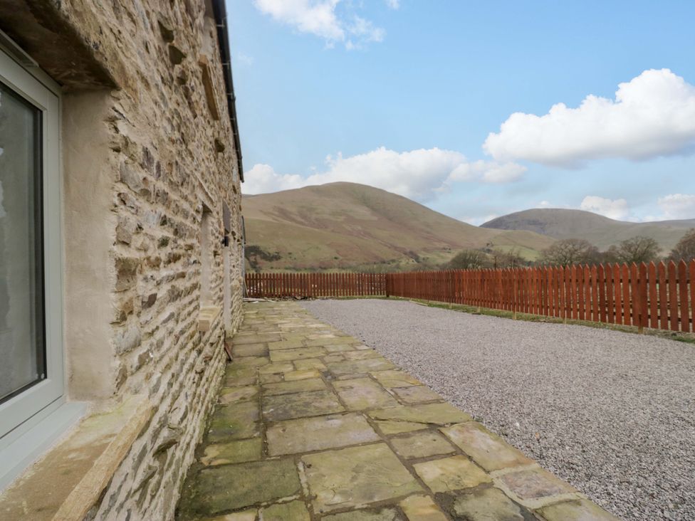 A view of a stone wall and a gravel area at New Barn Conversion in Sedbergh