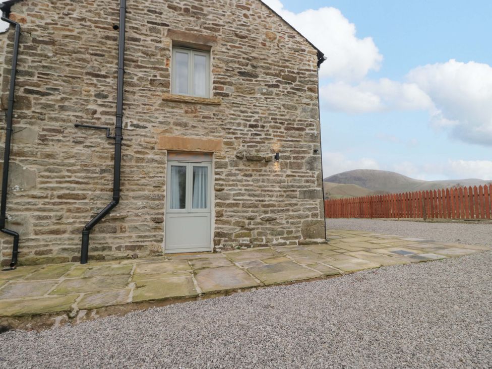 An outdoor area with a stone wall and door at New Barn Conversion Sedbergh