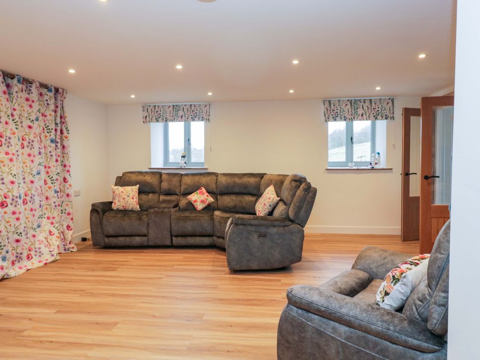 A living room with a sofa and curtains at New Barn Conversion in Sedbergh