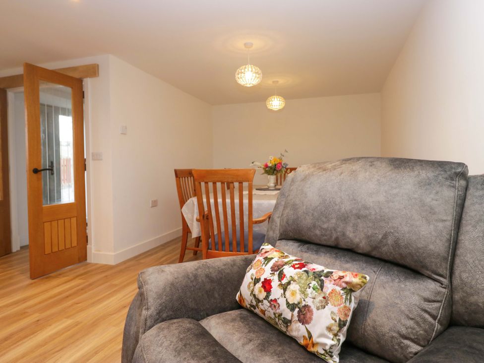 A dining room with a sofa and dining set at New Barn Conversion in Sedbergh