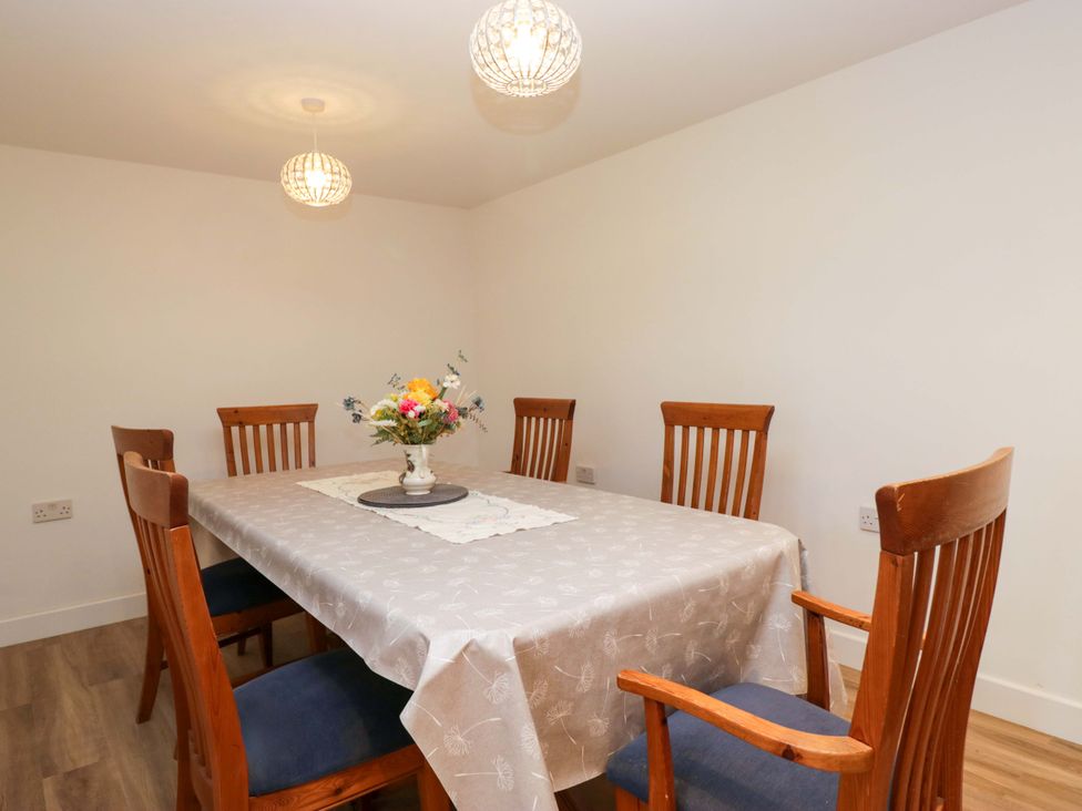 A dining room with a table and chairs at New Barn Conversion in Sedbergh