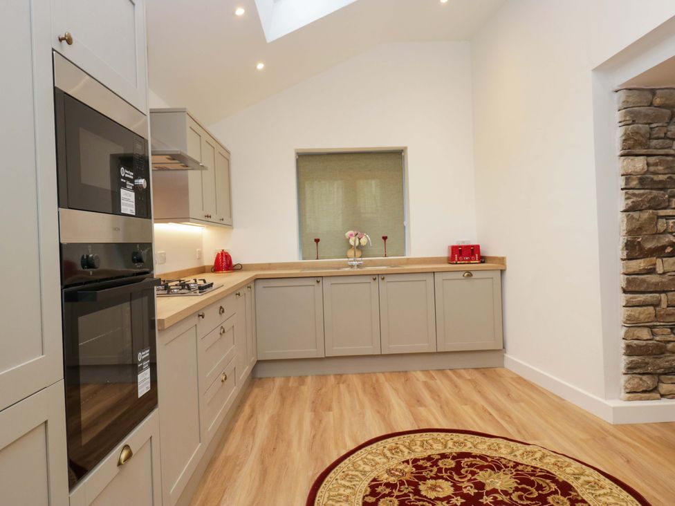A kitchen featuring cabinets, countertop, oven, and sink at New Barn Conversion in Sedbergh