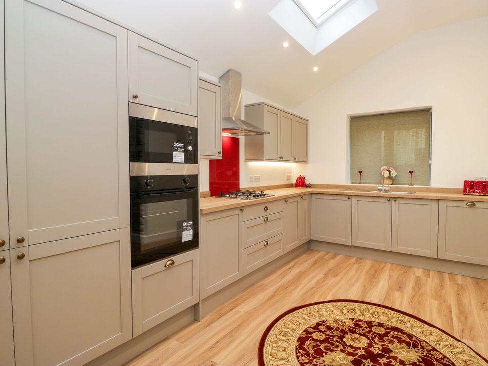 A kitchen with cabinets and appliances at New Barn Conversion in Sedbergh